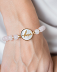 Bracelet with 'hope' charm on a wrist against a neutral background