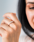 Close-up of a hand wearing a silver ring with a blurred background