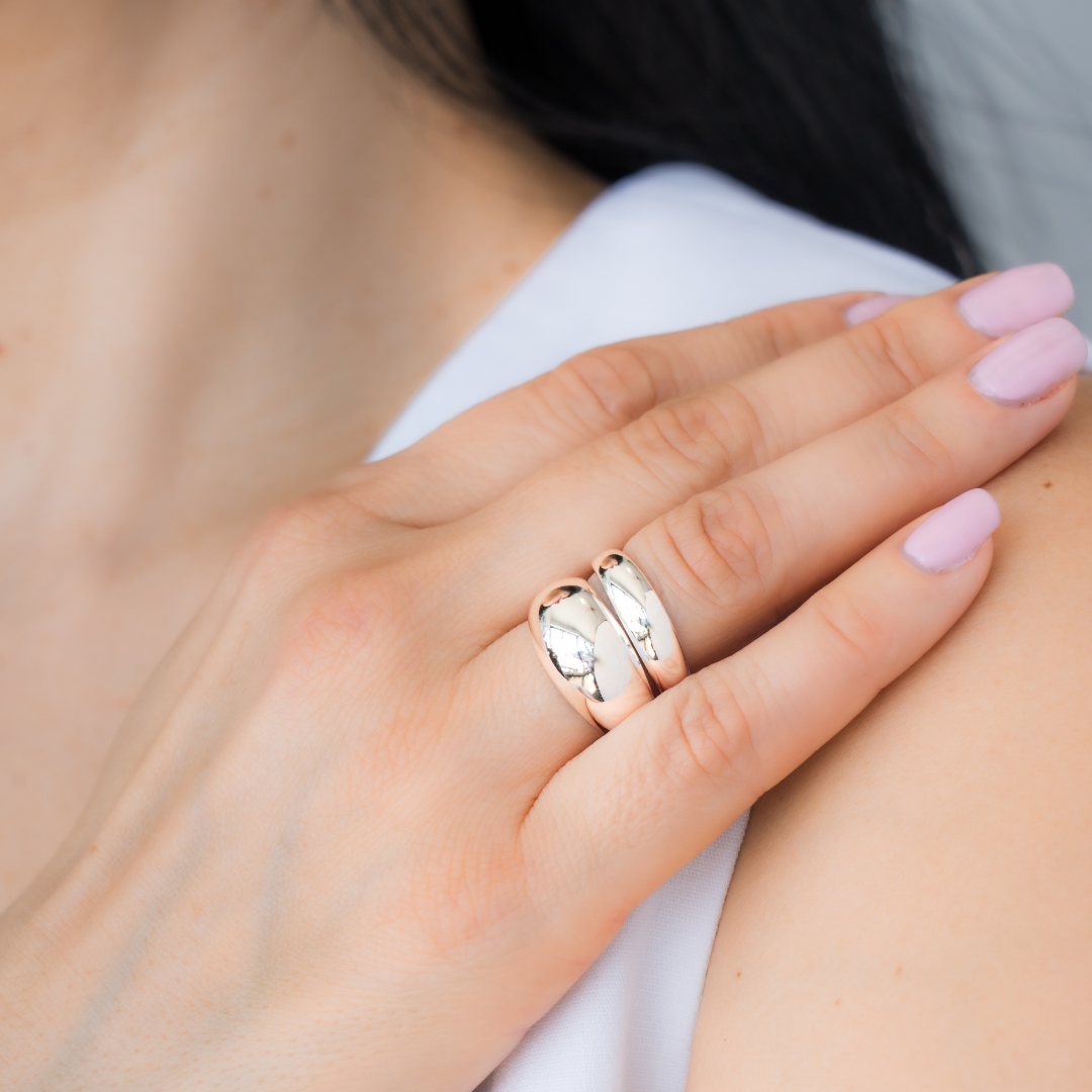 Close-up of a hand wearing two sterling silver rings; one is voluptuous and pairs perfectly with a smaller one, creating the perfect duo. / beblue bijoux
