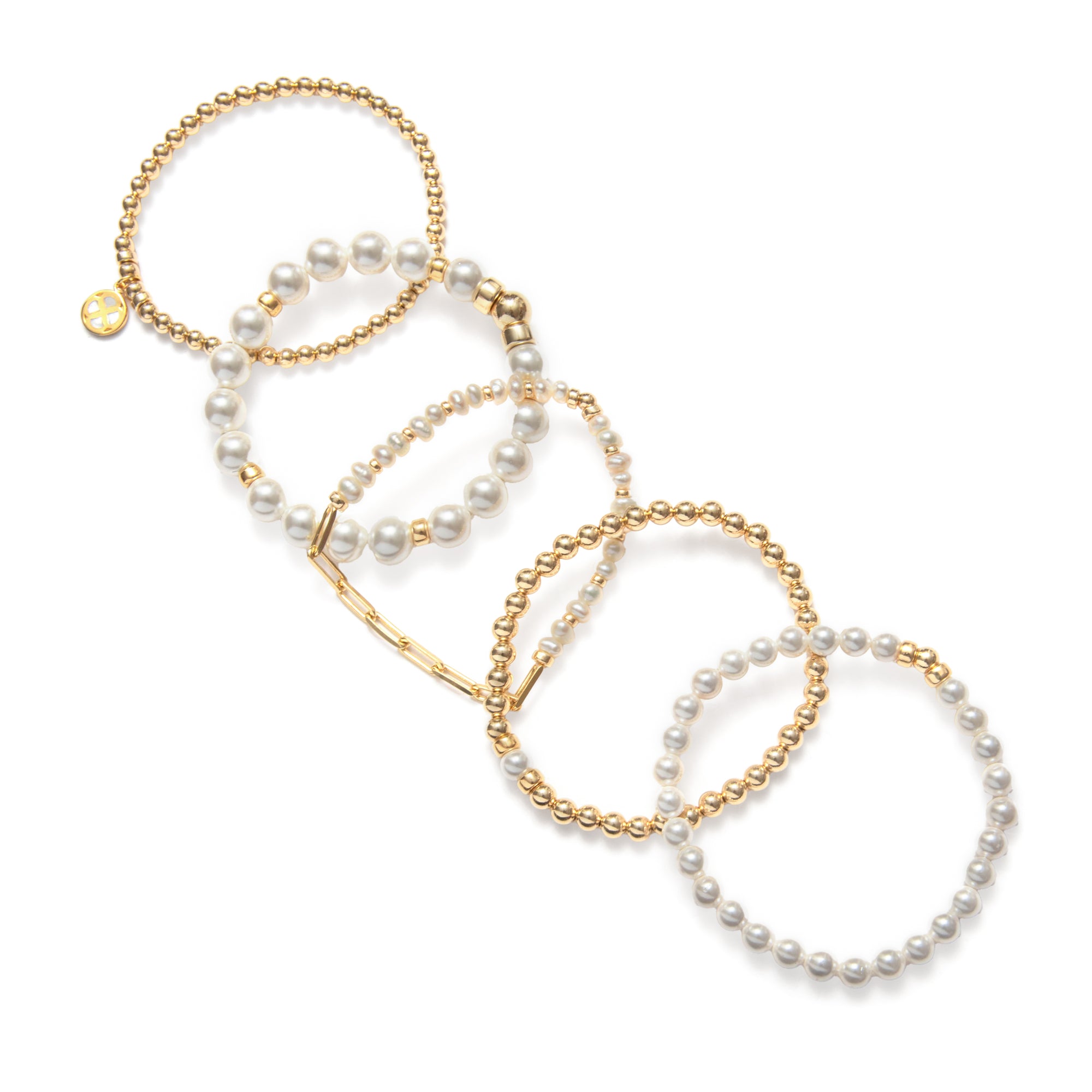 A person's hand showcasing a set of pearl bracelets with varying designs, worn on a white sleeveless top.