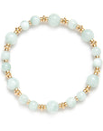 Bracelet with light blue beads and gold accents on a white background