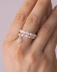 video of a Hand wearing multiple pearl rings on a neutral background