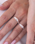 Close-up of a hand wearing two sterling silver rings on with a zircon.