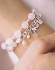 video of Bracelet with white beads and a palm tree charm on a wrist.