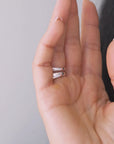 Close-up of a hand wearing two sterling silver rings; one is voluptuous and pairs perfectly with a smaller one, creating the perfect duo.