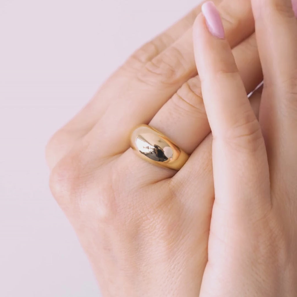 Close-up of a hand wearing two gold vermeil; one is voluptuous and pairs perfectly with a smaller one, creating the perfect duo. / beblue bijoux