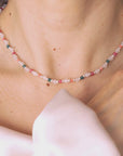 video of Close-up of a person wearing delicate necklace made of white agate with touches of color set in sterling silver.
